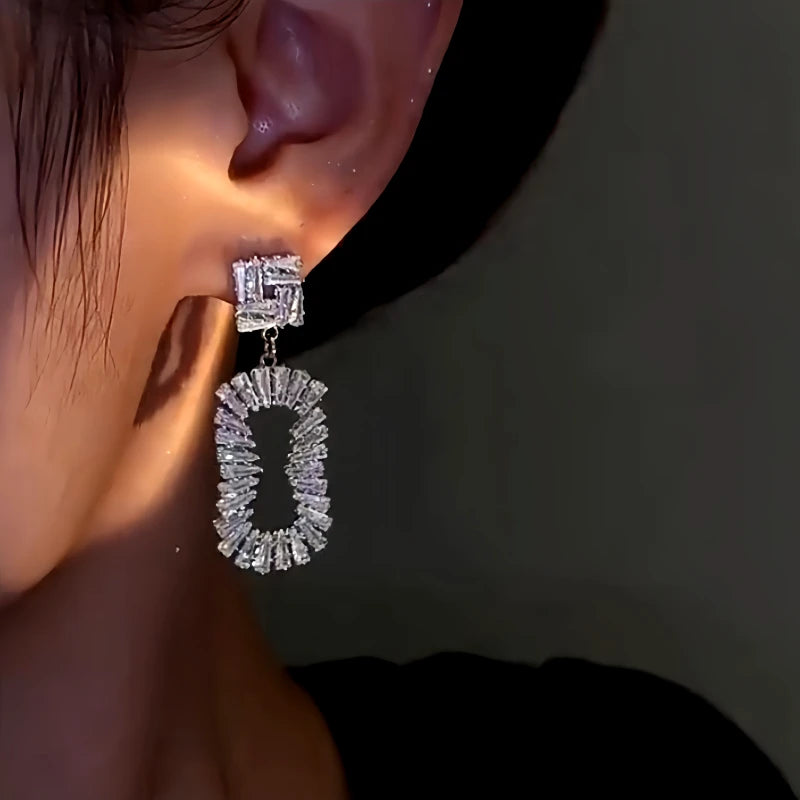Model showcasing the dangle and style of the 14K Gold-Plated Zircon Oval Earrings