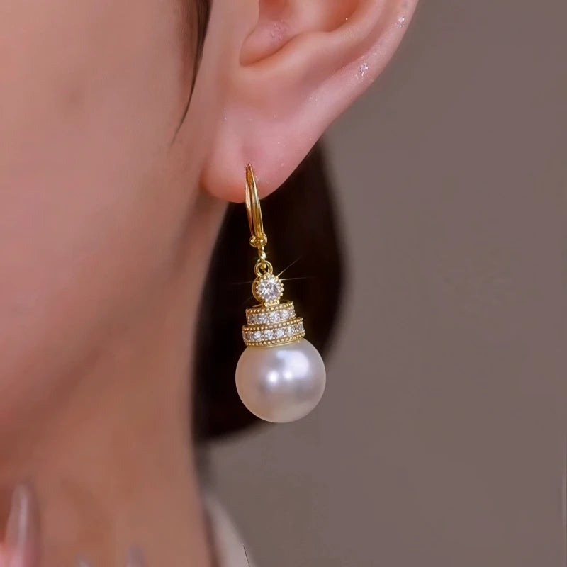 Model showcasing the dangle and style of the 14K Gold-Plated Zircon Pearl Earrings