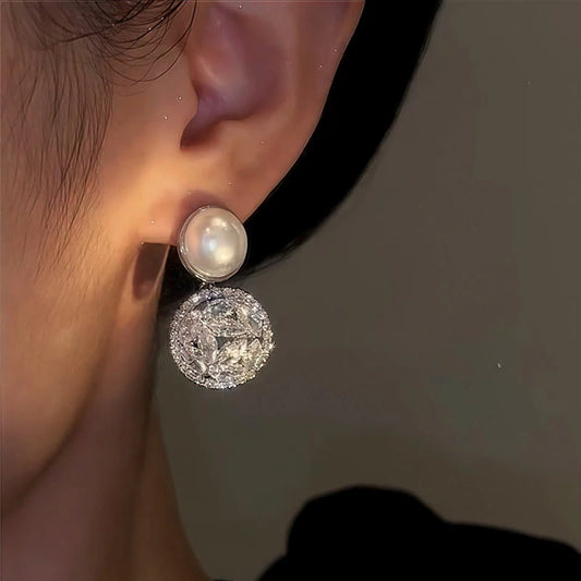 Model showcasing the dangle and style of the 14K Gold-Plated Zircon Pearl Earrings