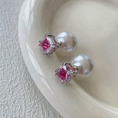 Pink square cubic zirconia pearl stud earrings on white ceramic dish