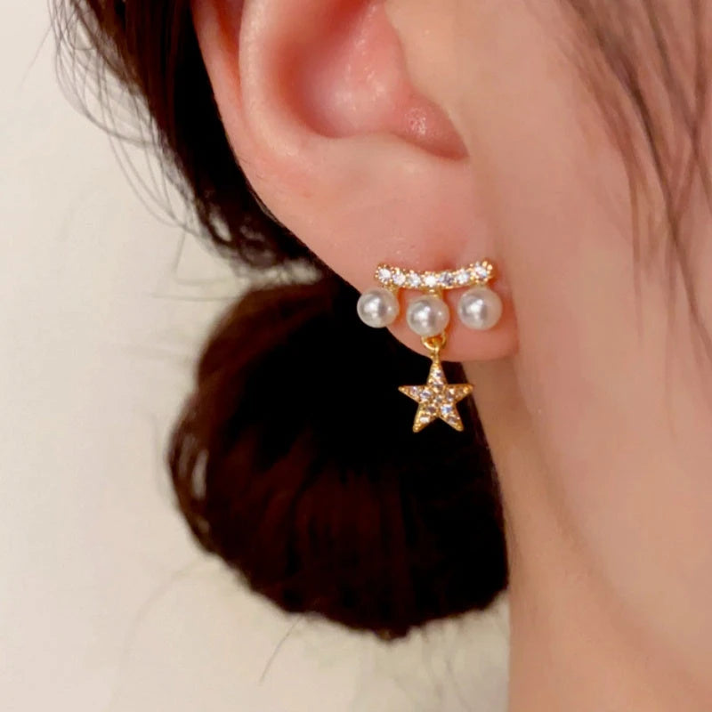 Model showcasing the dangle and style of the 14K Gold-Plated Zircon Pearl Star Earrings