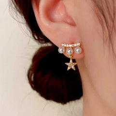 Model showcasing the dangle and style of the 14K Gold-Plated Zircon Pearl Star Earrings