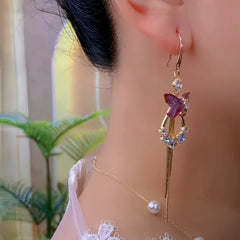 Purple butterfly crystal tassel drop earring worn on woman's ear