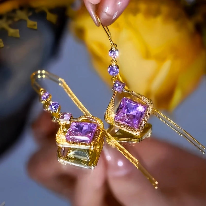 Angled view of the 14K Gold-Plated Zircon Purple Crystal Threader Earrings