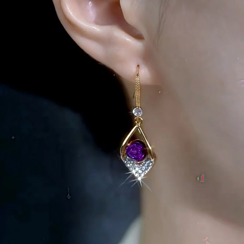 Women's gold purple rose gem crystal drop dangle earring worn on right ear
