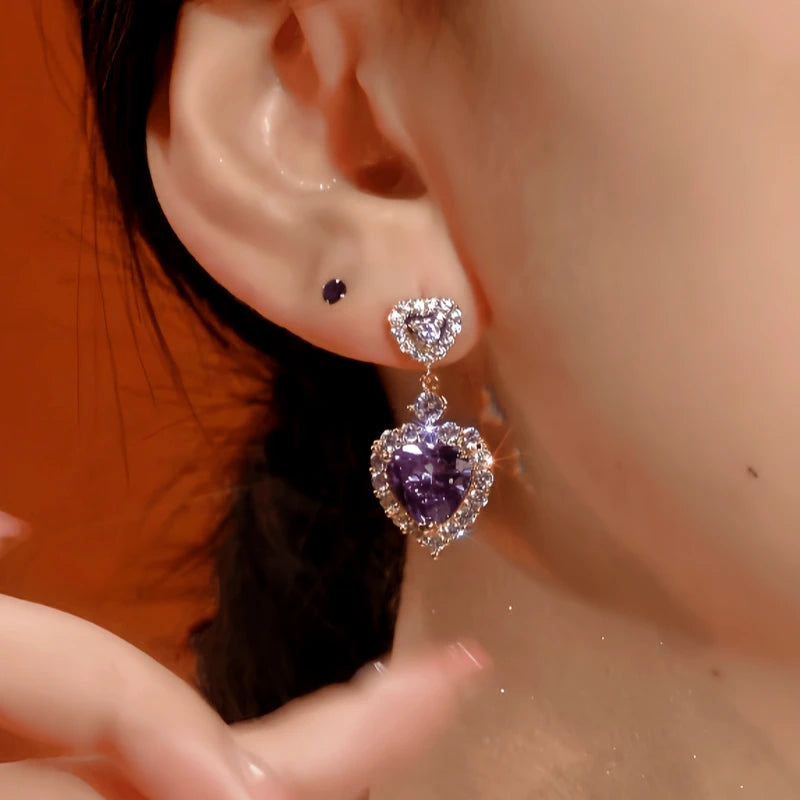 Model showcasing the dangle and style of the 14K Gold-Plated Zircon Purple Heart Earrings