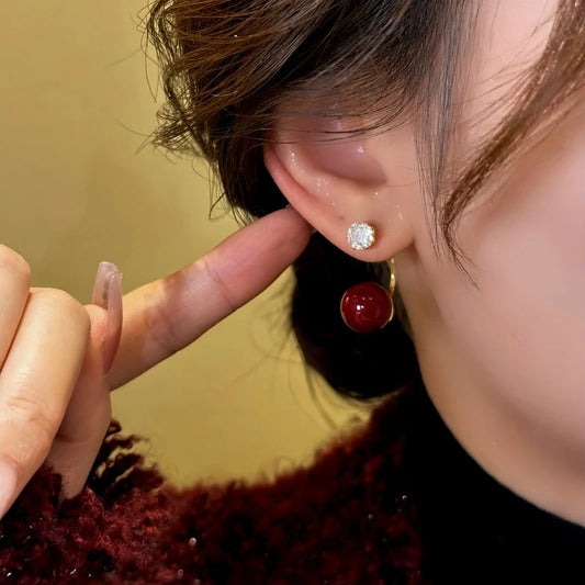 Model showcasing the dangle and style of the 14K Gold-Plated Zircon Red Bead Earrings