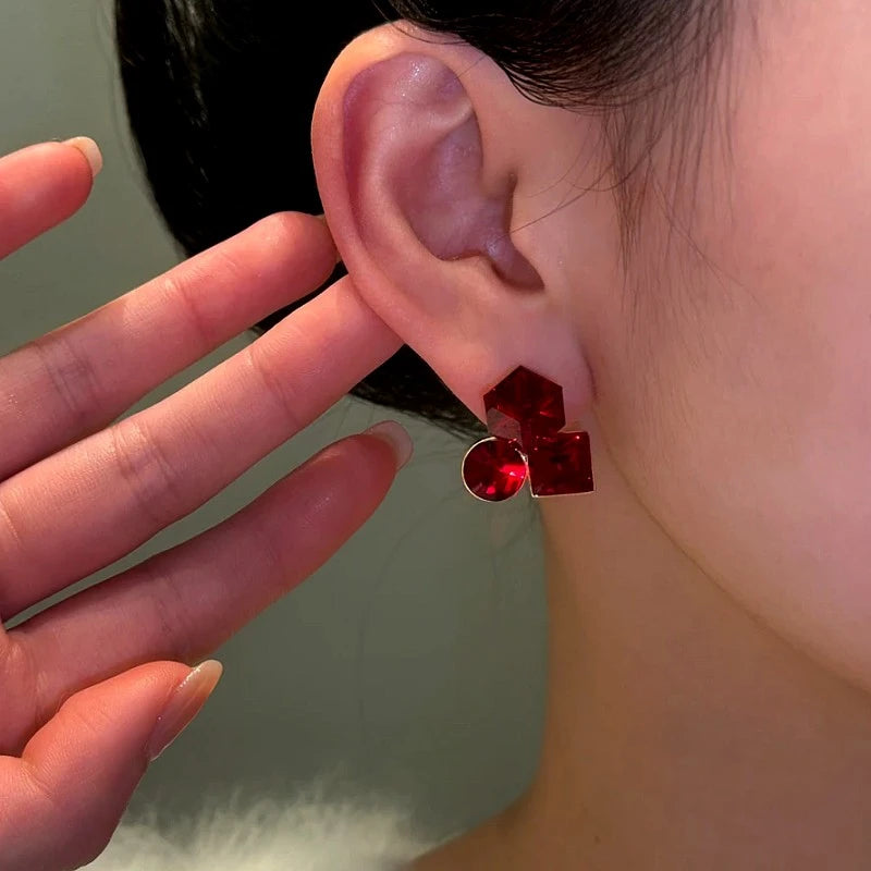 Model showcasing the dangle and style of the 14K Gold-Plated Zircon Red Crystal Stud Earrings