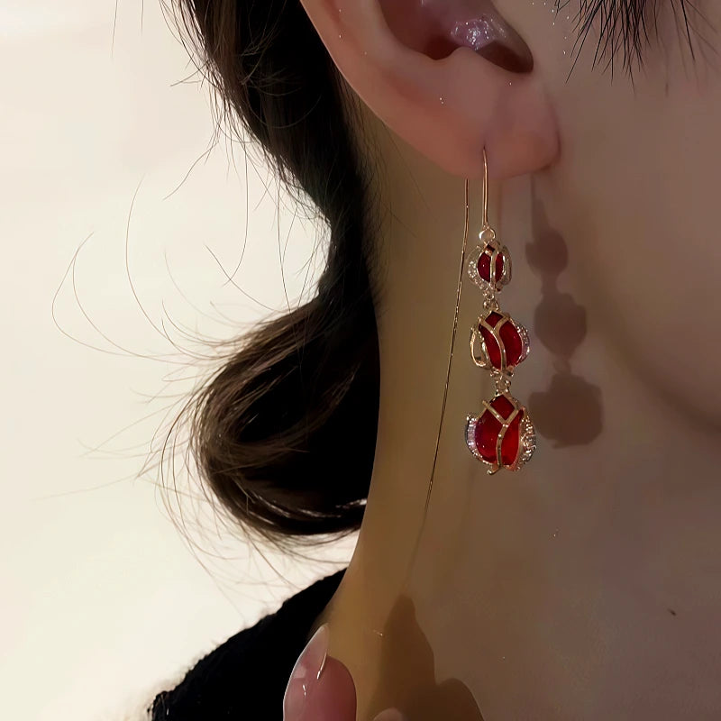 Angled view of the 14K Gold-Plated Zircon Red Crystal Tulip Flower Threader Earrings