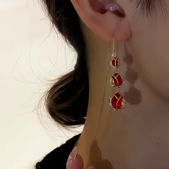Angled view of the 14K Gold-Plated Zircon Red Crystal Tulip Flower Threader Earrings