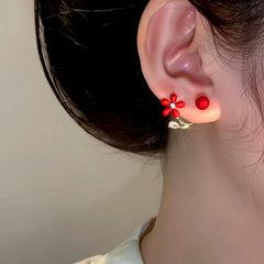 Model showcasing the dangle and style of the 14K Gold-Plated Zircon Red Flower Pearl Jacket Earrings