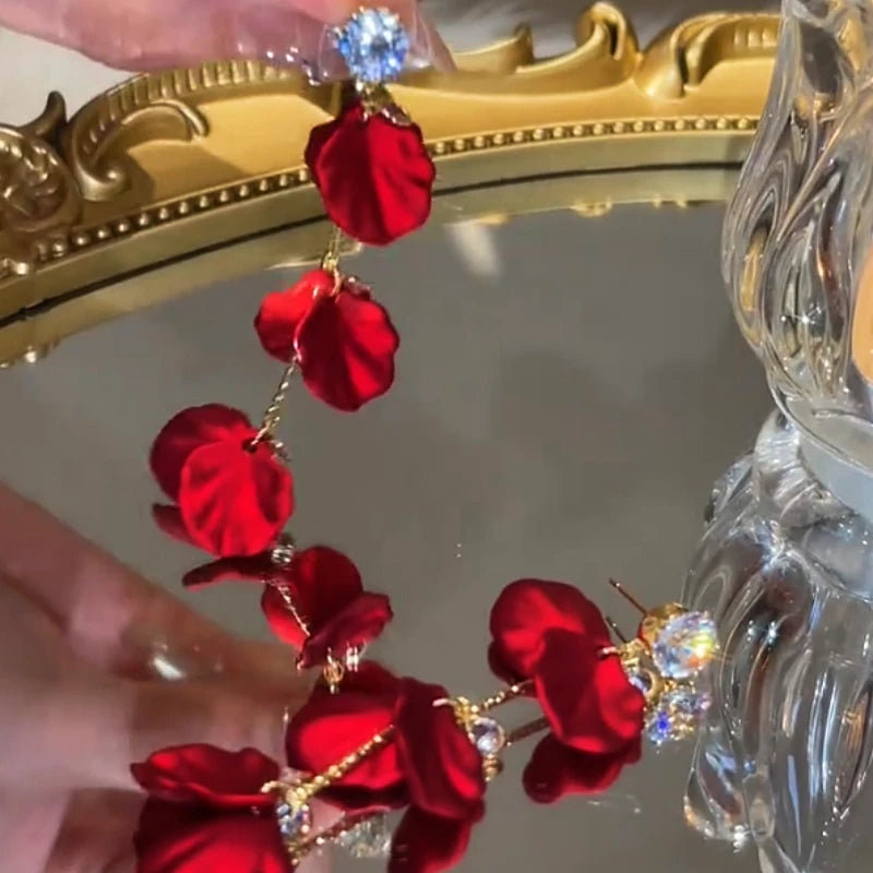 Layered red rose petal crystal stud dangle earrings on gold mirror with reflection