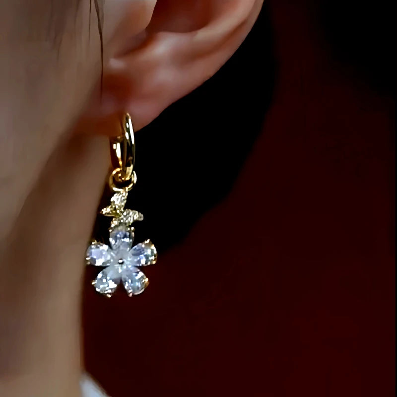 Model showcasing the dangle and style of the 14K Gold-Plated Zircon Small Flower Earrings