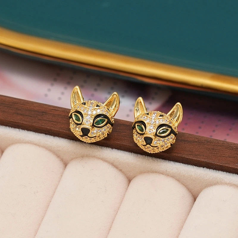 Pair of gold pave crystal cat head stud earrings with green gem eyes