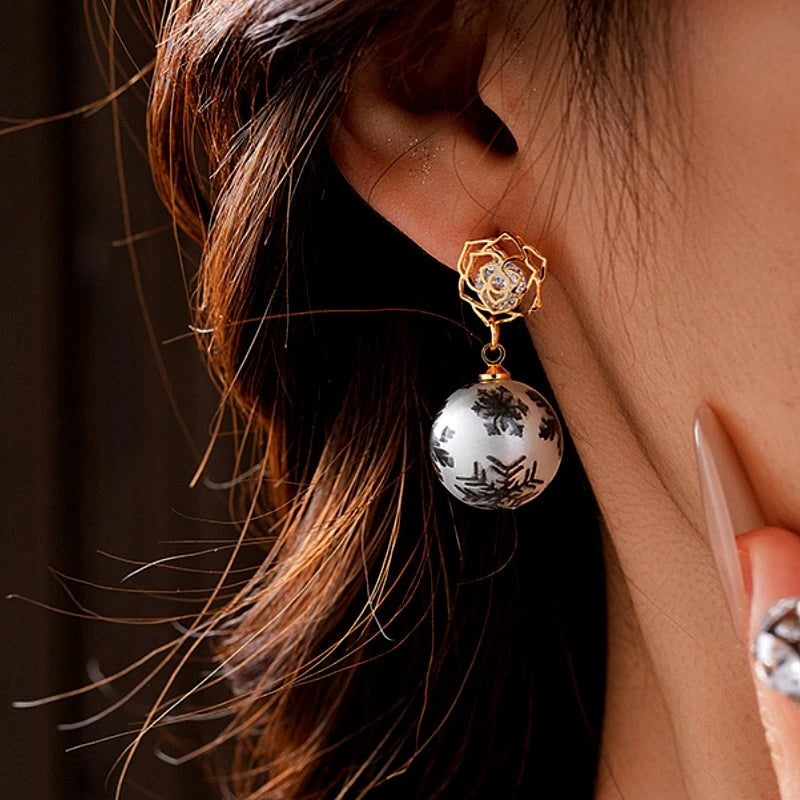 Angled view of the 14K Gold-Plated Zircon Snowflake Bead Earrings