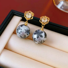 Model showcasing the dangle and style of the 14K Gold-Plated Zircon Snowflake Bead Earrings