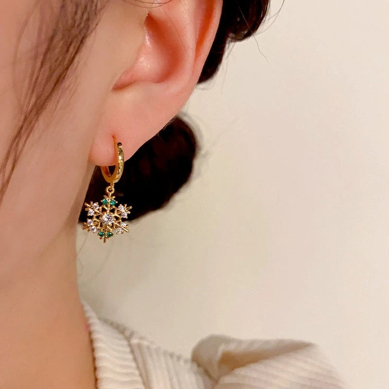 Model showcasing the dangle and style of the 14K Gold-Plated Christmas Zircon Snowflake Earrings