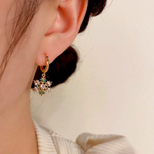 Model showcasing the dangle and style of the 14K Gold-Plated Christmas Zircon Snowflake Earrings