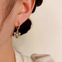 Model showcasing the dangle and style of the 14K Gold-Plated Christmas Zircon Snowflake Earrings
