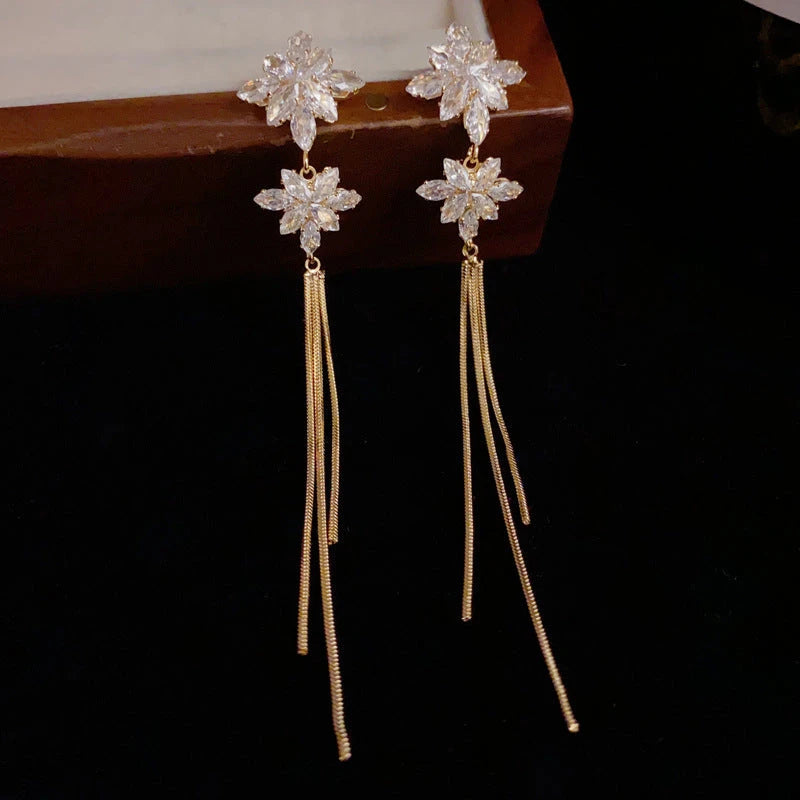 Model showcasing the dangle and style of the 14K Gold-Plated Zircon Snowflake Long Tassel Earrings