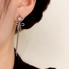 Model showcasing the dangle and style of the 14K Gold-Plated Zircon Star Bow Tassel Earrings