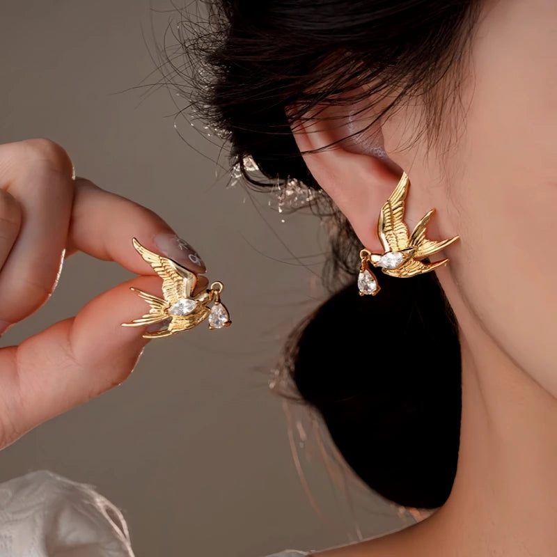 Model showcasing the dangle and style of the 14K Gold-Plated Zircon Swallow Water Drop Earrings