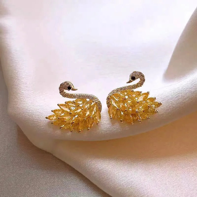 Model showcasing the dangle and style of the 14K Gold-Plated Zircon Swan Stud Earrings