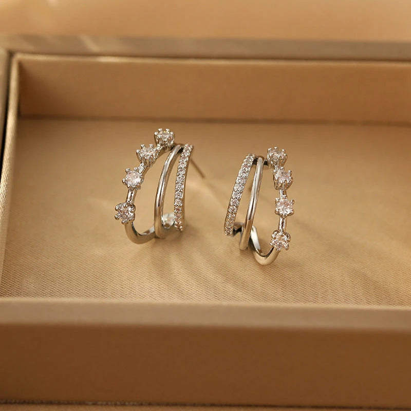 Pair of silver cubic zirconia studded triple hoop earrings in jewelry box