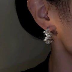 Model showcasing the dangle and style of the 14K Gold-Plated Zircon Toothed Hoop Earrings