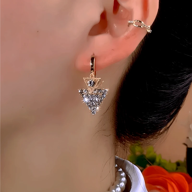 Model showcasing the dangle and style of the 14K Gold-Plated Zircon Triangular Diamond Earrings