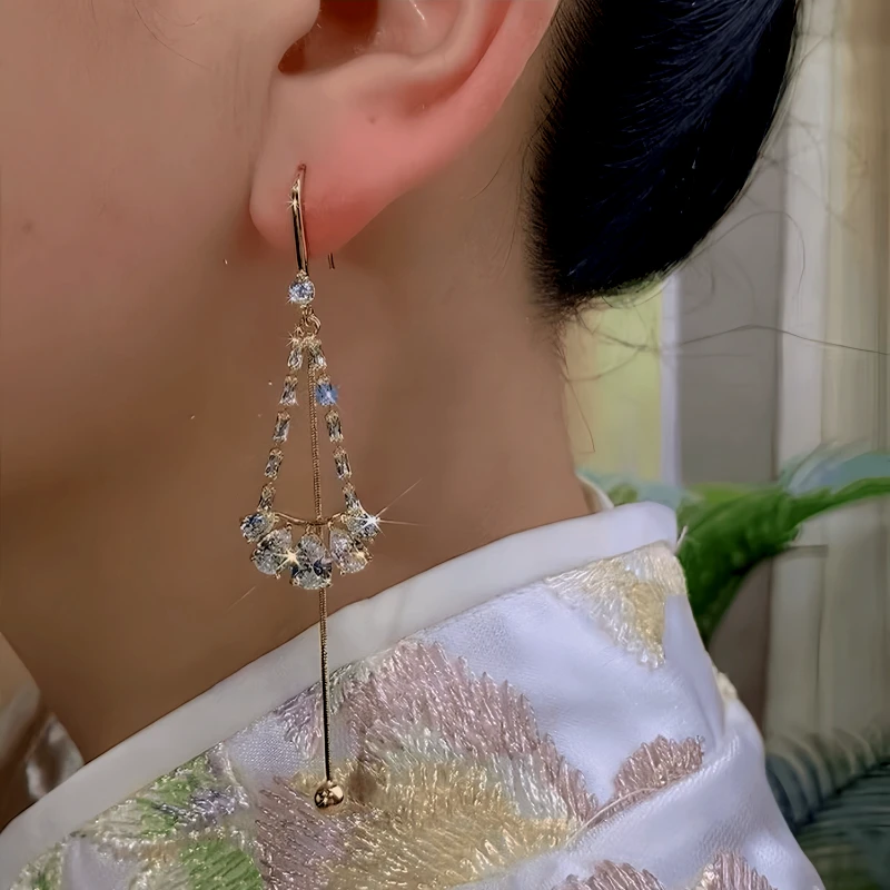 Model showcasing the dangle and style of the 14K Gold-Plated Zircon Water Drop Ear Hook Tassel Earrings