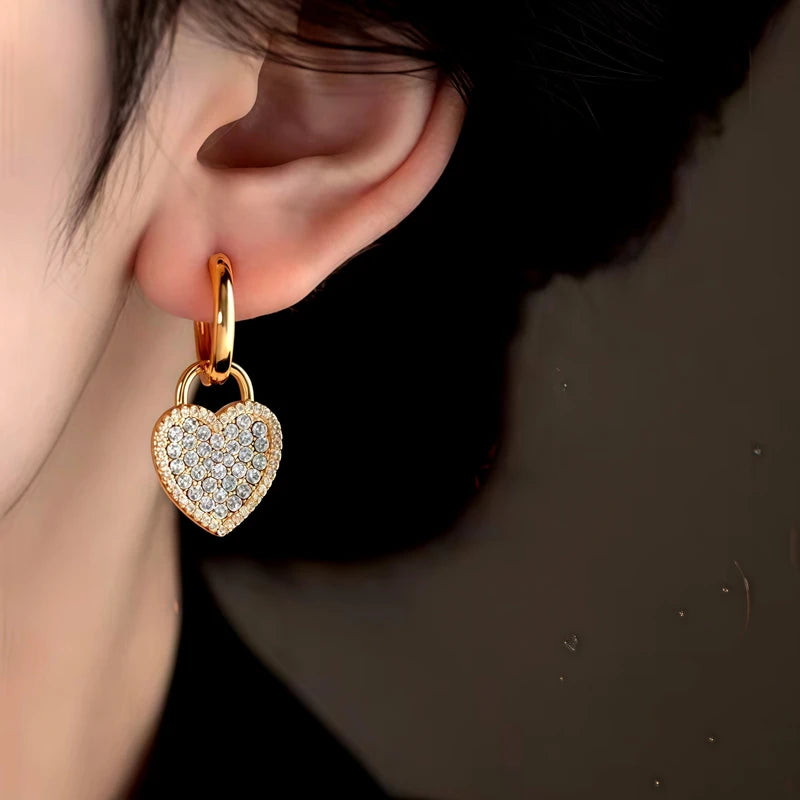 Model showcasing the dangle and style of the 14K Gold-Plated Zircon Diamond Heart Earrings