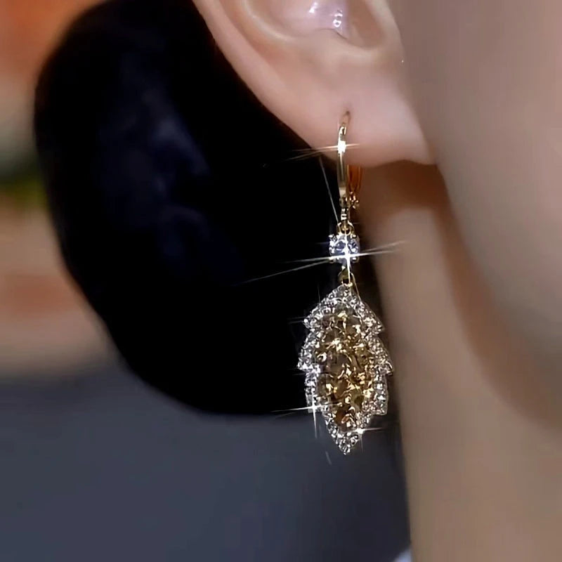 Model showcasing the dangle and style of the 14K Gold-Plated [One leaf tells the autumn] Earrings