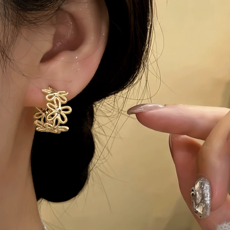 Model showcasing the dangle and style of the 14K Gold-Plated knot Flower C-Shaped Earrings