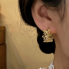 Close-up detail of the sparkling zircons and plating on the Knotted Flower Hoops