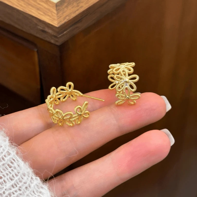 Angled view of the 14K Gold-Plated knot Flower C-Shaped Earrings