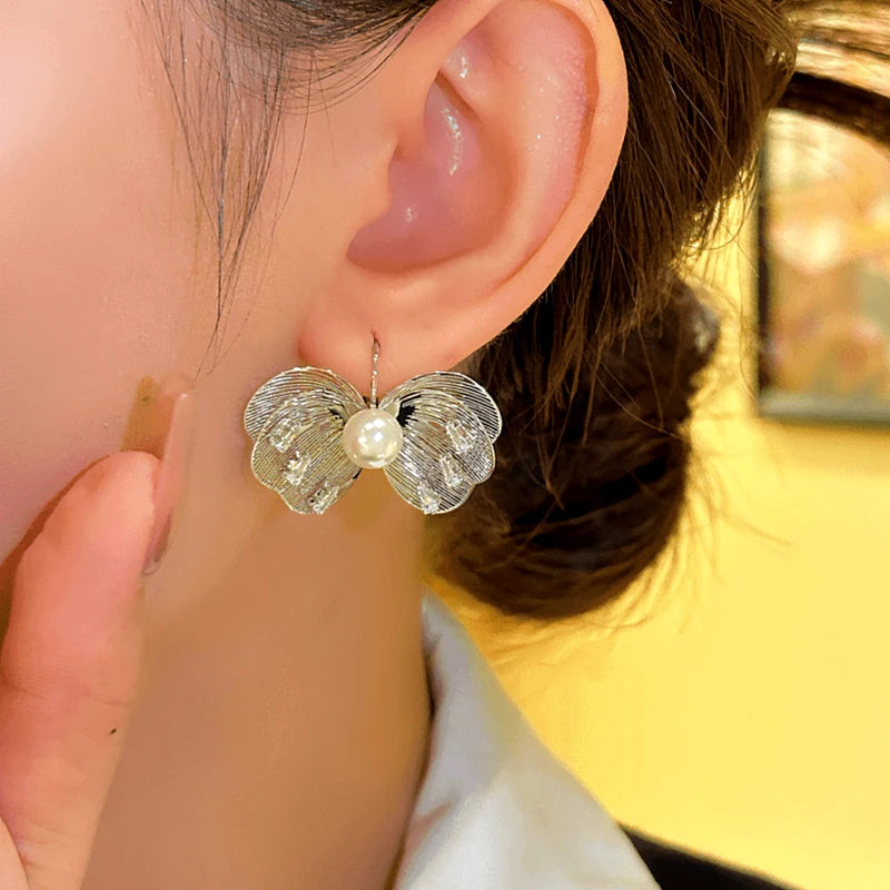 Model showcasing the dangle and style of the 14K Gold-plated Bead Butterfly Earrings