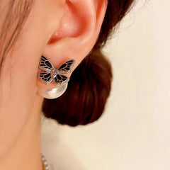 Model showcasing the dangle and style of the 14K Gold-plated Black Butterfly Pearl Jacket Earrings