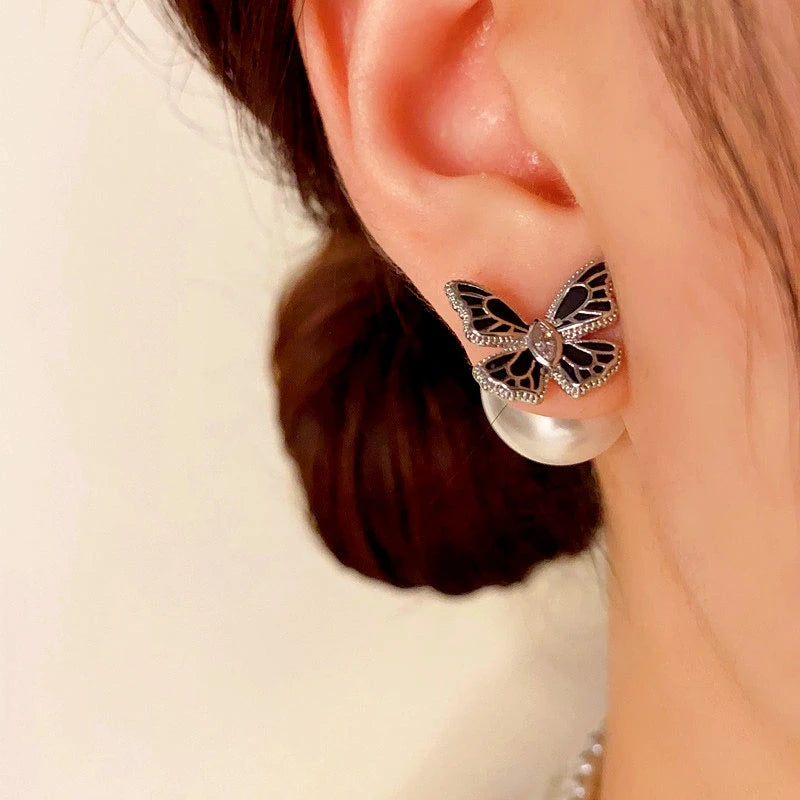 Close-up detail of the sparkling zircons and plating on the gold butterfly earrings