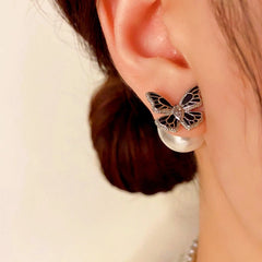 Close-up detail of the sparkling zircons and plating on the gold butterfly earrings