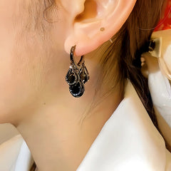 Model showcasing the dangle and style of the 14K Gold-plated Black Crystal Tassel Earrings
