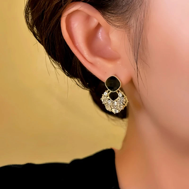 Model showcasing the dangle and style of the 14K Gold-plated Black Zircon Diamond Earrings