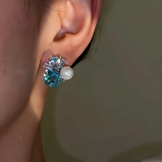Model showcasing the dangle and style of the 14K Gold-plated Blue Diamond Pearl Earrings