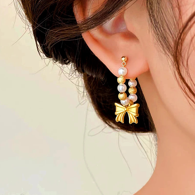 Model showcasing the dangle and style of the 14K Gold-plated Bow Beaded Earrings