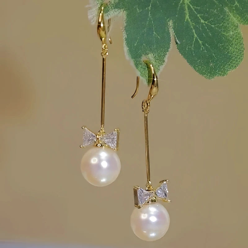 Angled view of the 14K Gold-plated Bow Long Pearl Ear Hook Earrings
