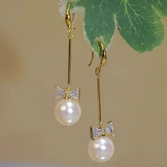 Angled view of the 14K Gold-plated Bow Long Pearl Ear Hook Earrings