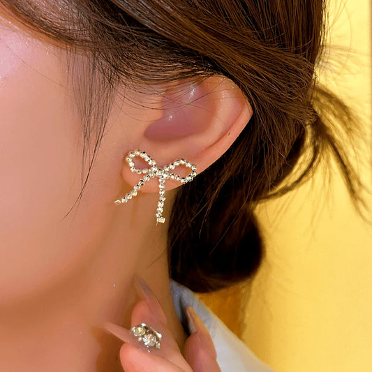Model showcasing the dangle and style of the 14K Gold-plated Bow Stud Earrings
