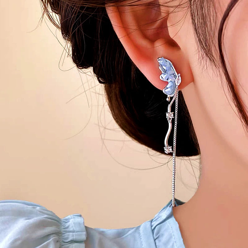 Model showcasing the dangle and style of the 14K Gold-plated Butterfly Tassel Earrings