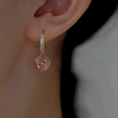 Model showcasing the dangle and style of the 14K Gold-plated Cat's Eye Pink And Green Drop Earrings