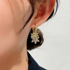 Model showcasing the dangle and style of the 14K Gold-plated Christmas Diamond Zircon Snowflake Earrings